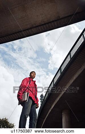 Stock Photo - teenage boy walking with books. Fotosearch