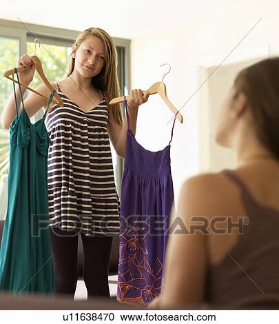 teenage girl showing dresses to mother View Large Photo Image Stock Image - teenage girl showing dresses to mother. Fotosearch
