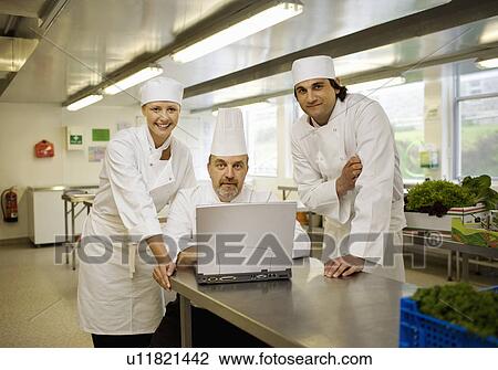 Stock Image - Three chefs looking at the camera. Fotosearch
