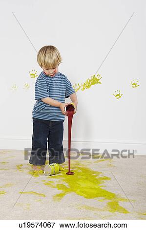 Stock Photo - Toddler boy pouring paint onto carpet. Fotosearch
