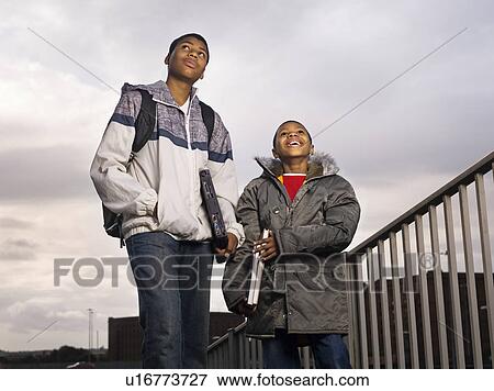 two boys walking with laptops View Large Photo Image Stock Photo - two boys walking with laptops. Fotosearch