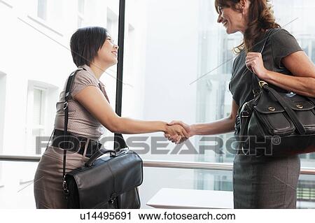 Two business women shaking hands View Large Photo Image Stock Image - Two business women shaking hands. Fotosearch
