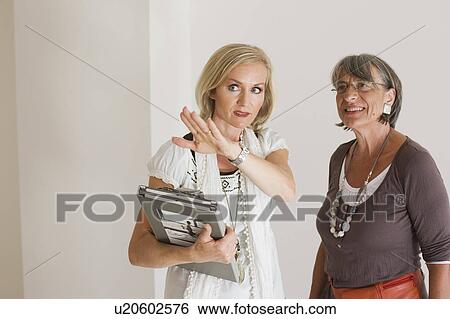 Stock Photograph - two businesswomen having a conversation. Fotosearch