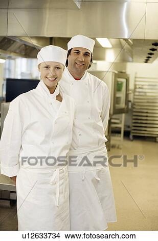 Picture - Two chefs in a kitchen smiling. Fotosearch