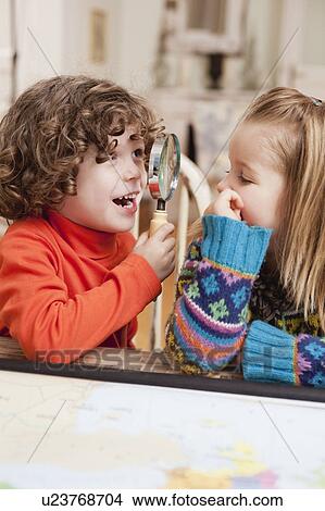 Picture - two children playing with magnifier. Fotosearch