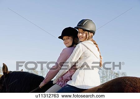 Two girls on a horseback View Large Photo Image Stock Image - Two girls on a horseback. Fotosearch