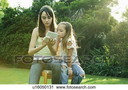 Two girls playing with Gameboy View Large Photo Image Stock Image - Two girls playing with Gameboy. Fotosearch