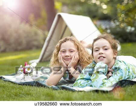 Two girls smiling at play picnic View Large Photo Image Stock Image - Two girls smiling at play picnic. Fotosearch
