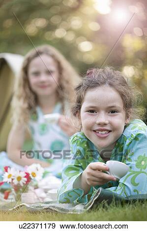 Two girls smiling at play picnic View Large Photo Image Stock Photo - Two girls smiling at play picnic. Fotosearch