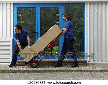 Stock Photography - two men carrying boxes on trolley. Fotosearch