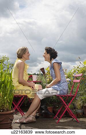 Stock Photo - two women hugging on balcony. Fotosearch