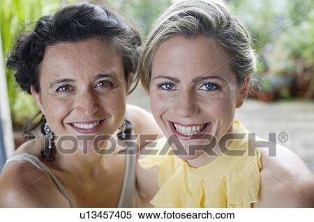 Stock Photography - two women hugging on balcony. Fotosearch