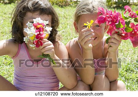 Two young girls with some flowers View Large Photo Image Stock Image - Two young girls with some flowers. Fotosearch