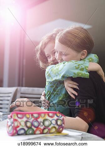 Two young sisters hugging in sunlight View Large Photo Image Picture - Two young sisters hugging in sunlight. Fotosearch