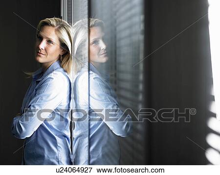 Stock Photo - Woman against window, thinking. Fotosearch