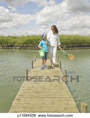 Woman and boy walking on jetty View Large Photo Image Stock Photo - Woman and boy walking on jetty. Fotosearch