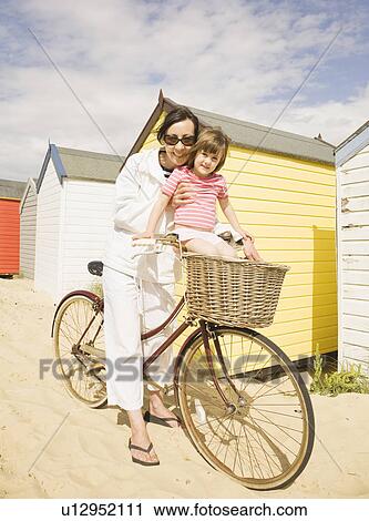 Stock Image - Woman and girl with bike. Fotosearch