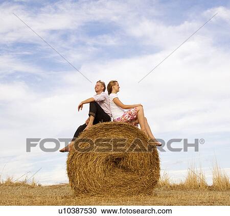 woman and man sitting on hay bale View Large Photo Image Stock Image - woman and man sitting on hay bale. Fotosearch