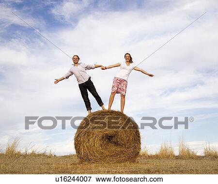 woman and man standing on hay bale View Large Photo Image Stock Photo - woman and man standing on hay bale. Fotosearch