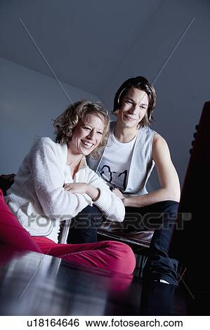 Stock Photograph - woman and young man watching TV together. Fotosearch