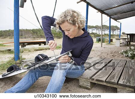 woman applying fin to her kiteboard View Large Photo Image Stock Image - woman applying fin to her kiteboard. Fotosearch