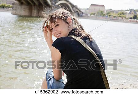 Stock Image - Woman by river smiling. Fotosearch