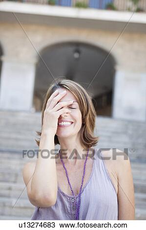 woman covering her eyes smiling View Large Photo Image Stock Image - woman covering her eyes smiling. Fotosearch