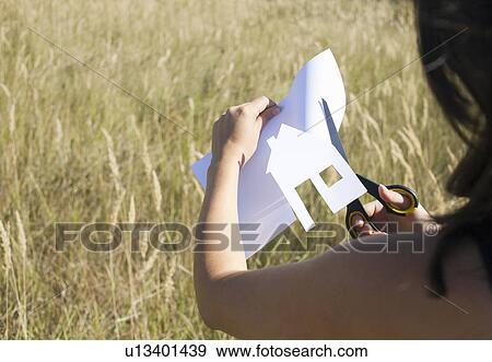 Woman cutting paper house View Large Photo Image Stock Photo - Woman cutting paper house. Fotosearch