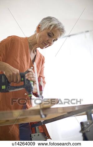 Stock Photo - woman doing mechanical skills. Fotosearch