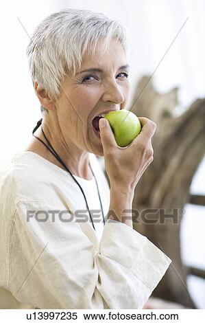 Stock Photography - woman eating an apple. Fotosearch