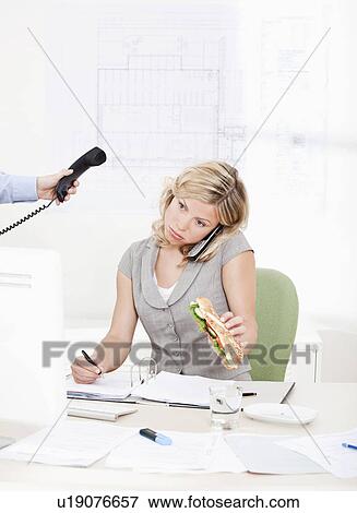 woman eating while on the phone View Large Photo Image Stock Photo - woman eating while on the phone. Fotosearch