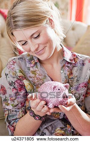 Stock Photography - woman emptying piggy bank. Fotosearch