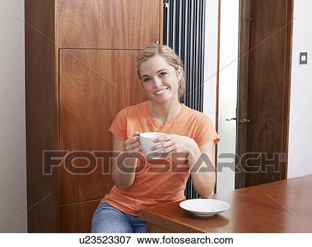 Woman having coffee in kitchen View Large Photo Image Stock Photo - Woman having coffee in kitchen. Fotosearch