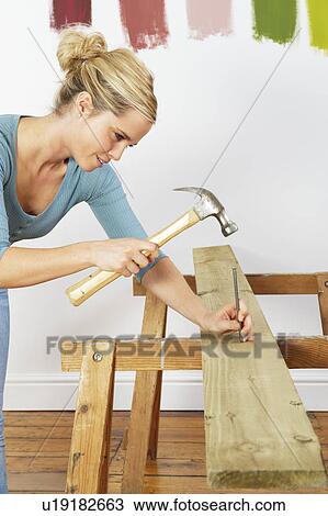 Woman hitting nail View Large Photo Image Stock Image - Woman hitting nail. Fotosearch