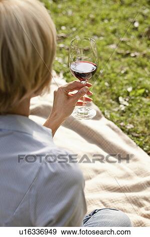 Woman holding a glass of wine View Large Photo Image Stock Photo - Woman holding a glass of wine. Fotosearch