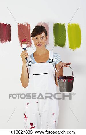 Stock Image - Woman holding paint brush and bucket. Fotosearch