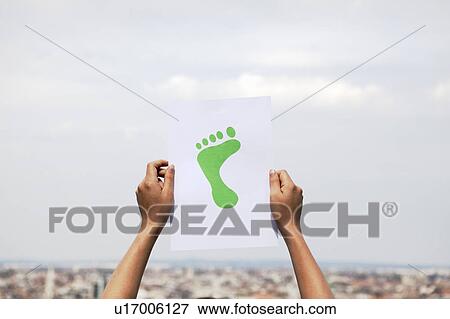 Woman holding paper green foot View Large Photo Image Stock Photo - Woman holding paper green foot. Fotosearch