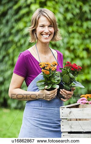 Stock Photo - woman holding two sets of flowers. Fotosearch