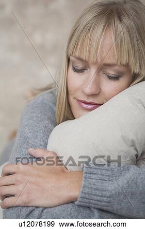 Stock Photo - woman hugging pillow. Fotosearch