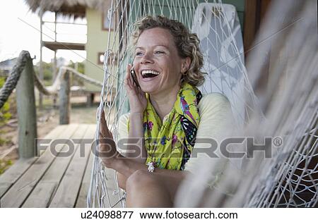 Stock Photo - woman in a hammock, talking on the phone. Fotosearch