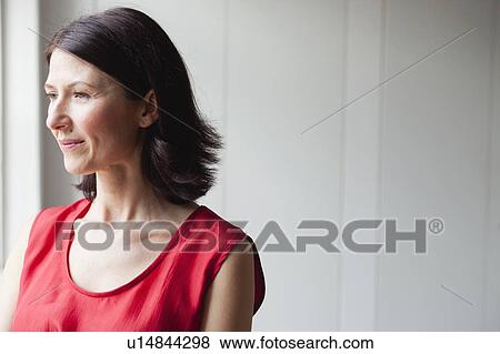 woman in red dress standing at window View Large Photo Image Stock Photo - woman in red dress standing at window. Fotosearch
