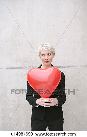 woman in suit holding heart balloon View Large Photo Image Stock Image - woman in suit holding heart balloon. Fotosearch