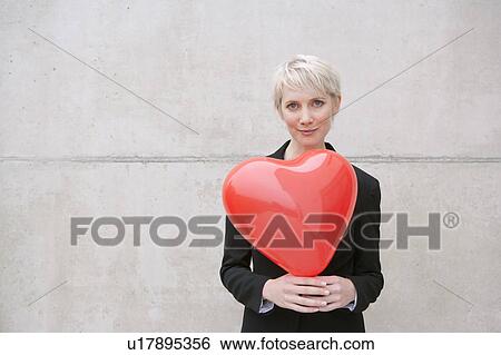 woman in suit holding heart balloon View Large Photo Image Stock Photograph - woman in suit holding heart balloon. Fotosearch