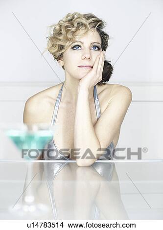 Picture - woman in swimsuit with cocktail thinking. Fotosearch