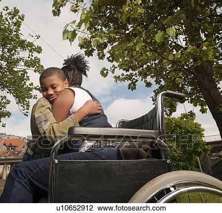 Stock Image - woman in wheelchair with child. Fotosearch