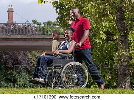 Stock Image - woman in wheelchair with family. Fotosearch