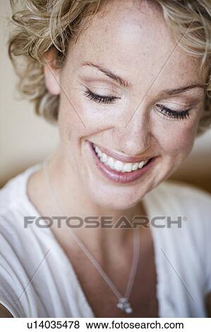 Stock Photo - woman in white shirt smiling. Fotosearch