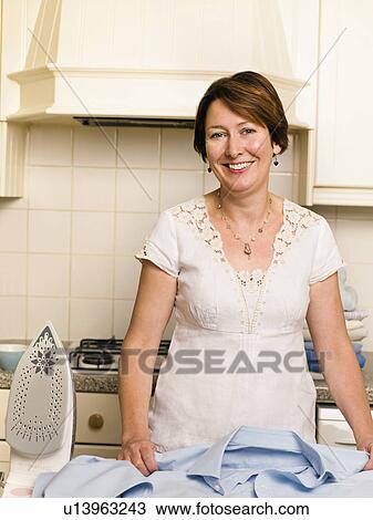 Woman ironing in her kitchen View Large Photo Image Stock Image - Woman ironing in her kitchen. Fotosearch