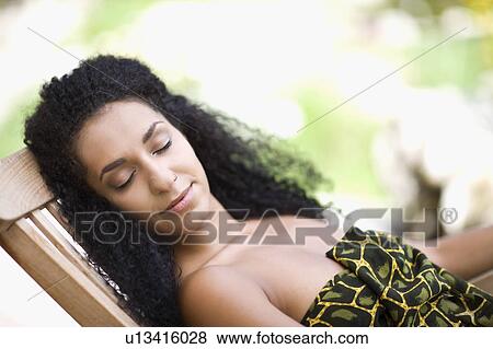Stock Photo - woman lies on a lounger. Fotosearch