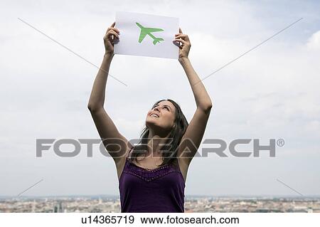 Stock Photo - Woman lifting paper green plane. Fotosearch